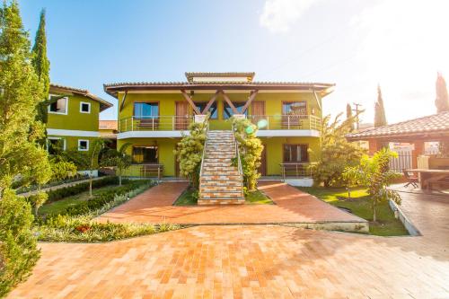 a yellow house with a staircase in front of it at Vila Miola Hotel in Porto Seguro