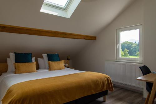a bedroom with a bed with a yellow blanket and a window at Amodo Lodge in Saint-Paul-en-Chablais