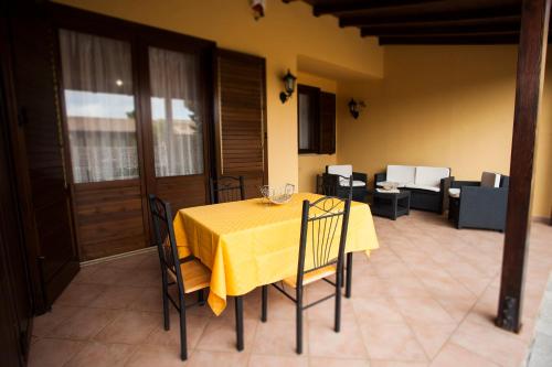 a dining room table with a yellow table cloth at AROMA GARDEN in San Vito lo Capo