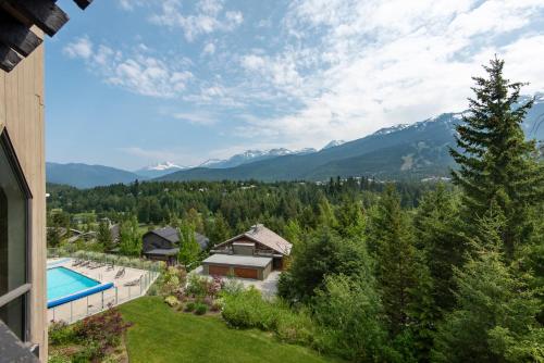 an aerial view of a house with a swimming pool and mountains at The Ironwood on Blueberry Hill in Whistler