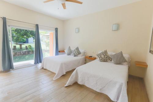 聖塔瑪麗亞德洛羅的住宿－Habitaciones Lucero 4，白色的客房设有两张床和窗户。