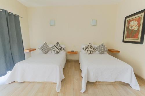 a room with two beds with white sheets at Habitaciones Lucero 4 in Santa María del Oro