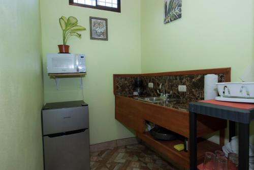a kitchen with a stove and a microwave at Hotel Sunshine Caribe in Puerto Viejo