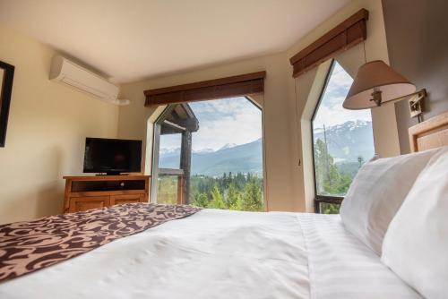 a bedroom with a bed and a large window at The Ironwood on Blueberry Hill in Whistler