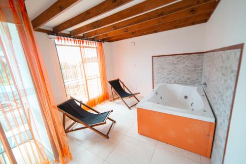 a bathroom with two chairs and a bath tub at Hotel Syvanna Wellness and Spa in Pereira