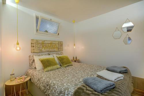 ein Schlafzimmer mit einem Bett mit zwei Kissen darauf in der Unterkunft Traditional Apartment with a Terrace, AC and Fast Internet in Lissabon