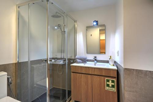 La salle de bains est pourvue d'une douche, d'un lavabo et d'un miroir. dans l'établissement Traditional Apartment with a Terrace, AC and Fast Internet, à Lisbonne