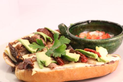 a sandwich with meat and vegetables and a bowl of soup at Hotel Ferri in Oaxaca City