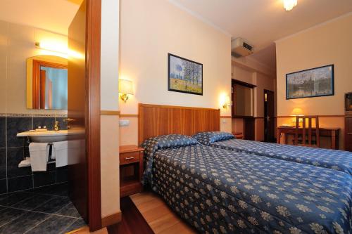 Hotel Frate Sole في أسيسي: غرفة الفندق بسرير ومغسلة