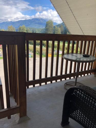 a balcony with a table and a view of the mountains at Peaks Lodge in Revelstoke