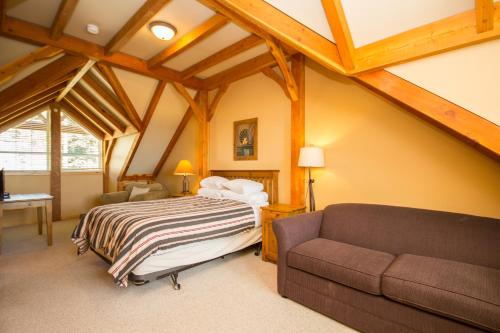 ein Schlafzimmer mit einem Bett und einem Sofa in der Unterkunft 3 BR 3 Bath ski in ski out with private hot tub in Big White