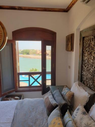 a bedroom with a bed and a view of the water at Dar Om Ali ElGouna Sabina y160 2 14 in El Gouna