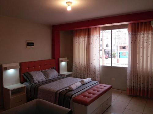 1 dormitorio con cama y ventana grande en La Quilla House en Lima