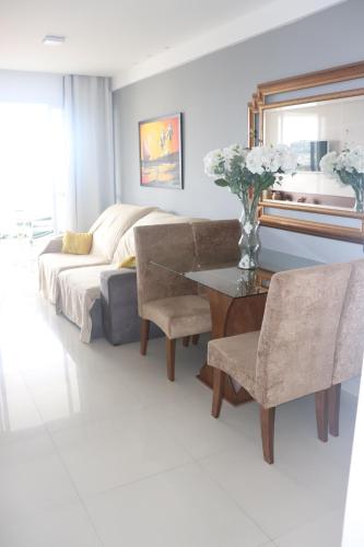 a bedroom with a bed and a table and chairs at Apartamento Residencial Julia in Guarapari