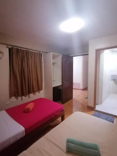 a room with two beds and a red mattress at Manora Apartment in Talisay