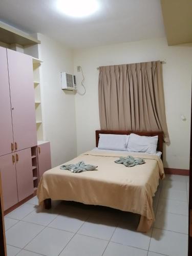 a bedroom with a large bed with a window at Manora Apartment in Talisay
