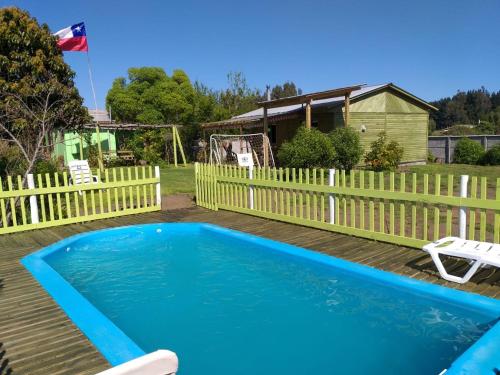 una piscina en una terraza con una valla en Cabañas Don Tito, en Buchupureo