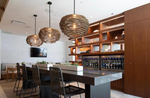 a bar in a room with chairs and pendant lights at 'Alohilani Resort Waikiki Beach in Honolulu