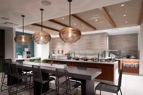 a kitchen with a large table with chairs and lights at 'Alohilani Resort Waikiki Beach in Honolulu
