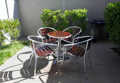 a table and four chairs sitting on a patio at Alpine Lake Motel in Taupo