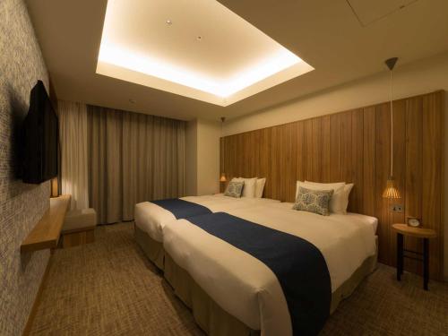 Ένα ή περισσότερα κρεβάτια σε δωμάτιο στο Tokyu Stay Okinawa Naha