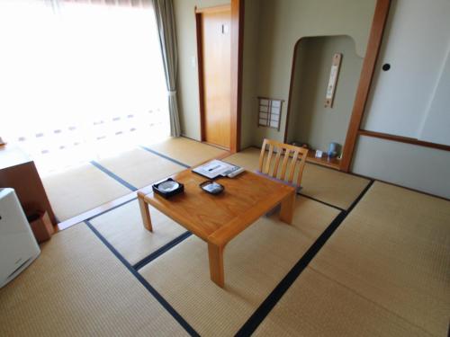 sala de estar con mesa de madera y silla en Manseiro en Nachikatsuura