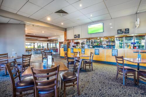 a restaurant with tables and chairs and a tv at Nightcap at Riverside Hotel in Launceston