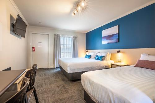um quarto de hotel com duas camas e uma televisão de ecrã plano em Nightcap at Riverside Hotel em Launceston