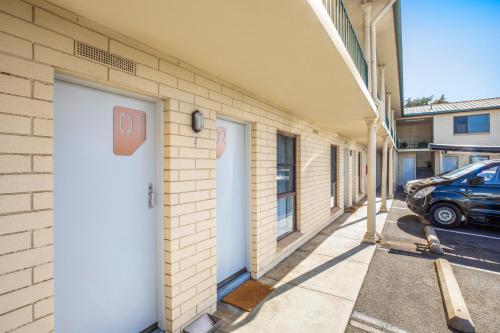 a building with a white door and a parking lot at Nightcap at Riverside Hotel in Launceston