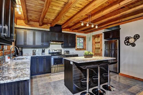 a kitchen with dark wood cabinets and a large island at 36- Chalet à louer à Stoneham in Stoneham