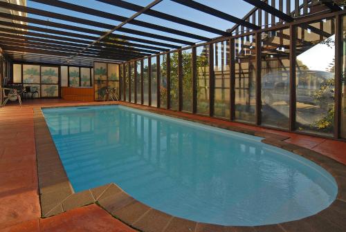 a large swimming pool in a building with windows at Albatross Motel in Napier
