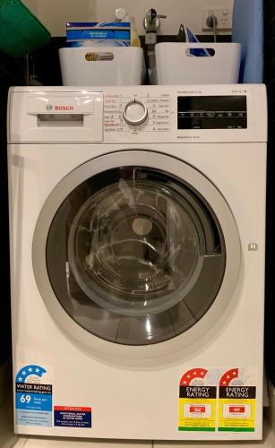 a white washing machine sitting in a kitchen at Boutique Abode 313 in Melbourne