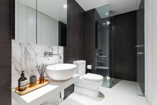 a bathroom with a white toilet and a sink at Boutique Abode 313 in Melbourne