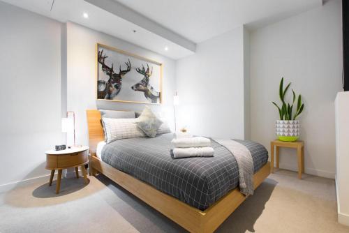 a bedroom with a bed and a table with a lamp at Boutique Abode 313 in Melbourne