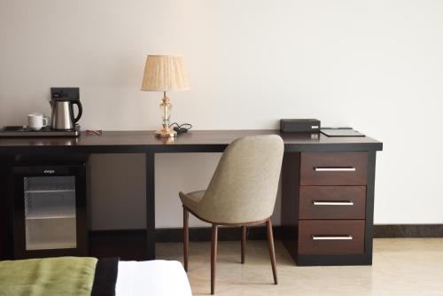 a desk with a chair and a lamp on it at Ruvisha Beach Hotel in Negombo