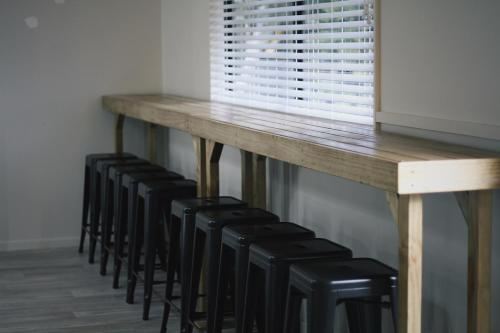 a table with a row of black stools around it at Hugo & Carters Backpackers & Motel in Tauranga
