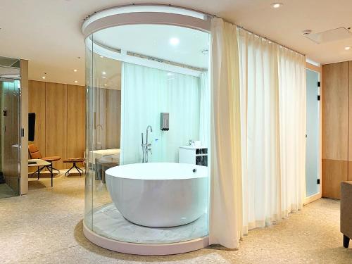 a large bathroom with a tub in a room at Biennale Hotel in Gwangju