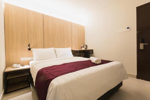 a bedroom with a large bed with a wooden headboard at GM Hotel Kuantan in Kuantan