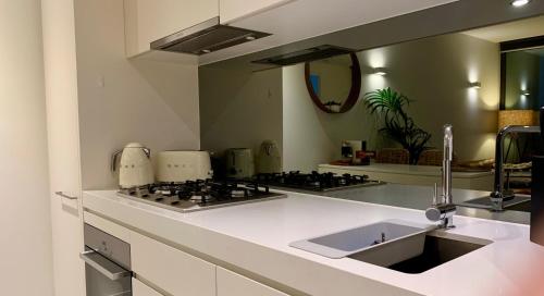uma cozinha com um lavatório e uma bancada em Boutique Abode 314 em Melbourne
