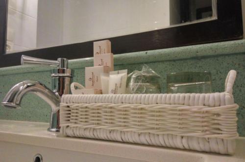 a white basket sitting on a sink in a bathroom at Jambuluwuk Oceano Seminyak Hotel in Seminyak