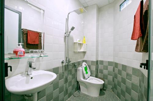 ein Bad mit einem Waschbecken und einem WC in der Unterkunft Happy Town Hoi An in Hoi An