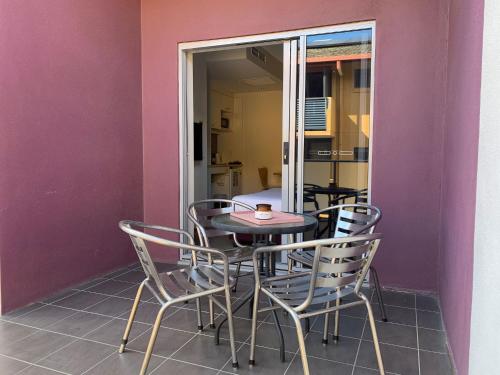 a table and chairs in a room with a purple wall at Airport Ascot Motel in Brisbane