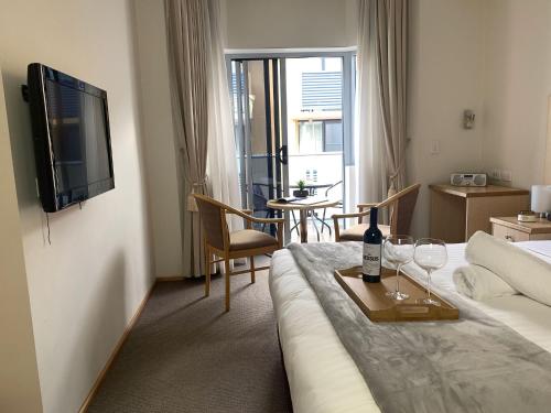 a hotel room with a bed and a table with wine glasses at Airport Ascot Motel in Brisbane