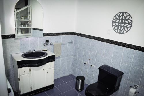 uma casa de banho com um lavatório e um WC. em TRAVELER'S HOUSE QUITO em Quito