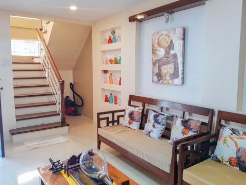 a living room with two benches and a staircase at RedDoorz @ Caimito Drive Dampas in Tagbilaran City