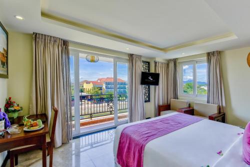 a hotel room with a bed and a large window at River Suites Hoi An in Hoi An