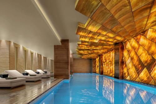 a pool in a hotel with chairs and a swimming pool at Hyatt Centric Levent Istanbul in Istanbul