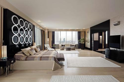 um quarto com uma cama grande e uma sala de estar em Hyatt Centric Levent Istanbul em Istambul