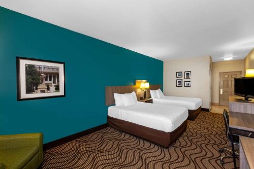 a hotel room with two beds and a blue wall at La Quinta by Wyndham Midland North in Midland