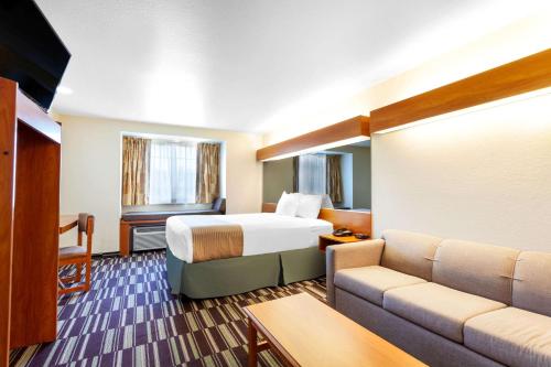 une chambre d'hôtel avec un lit et un canapé dans l'établissement Microtel Inn & Suites by Wyndham Gulf Shores, à Gulf Shores